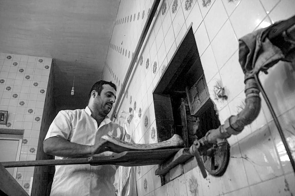 A baker preparing bread in a traditional bakery in Behshahr, Iran.